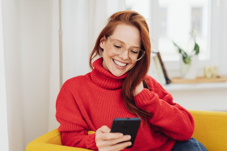 Frau bedient ein Smartphone zur Terminvereinbarung für eine Wohnungsbesichtigung